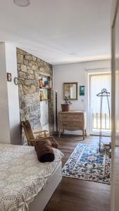 Un dormitorio con una cama y una pared de piedra. en Ninho do Melro II - Turismo Rural Bragança, en Bragança
