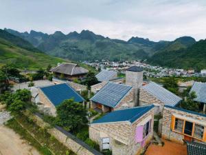 an aerial view of a village with mountains in the background at Thào Gia Homestay Mèo Vạc in Ha Giang