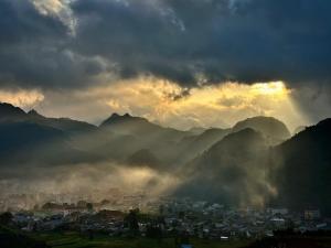 a view of a city with mountains in the background at Thào Gia Homestay Mèo Vạc in Ha Giang