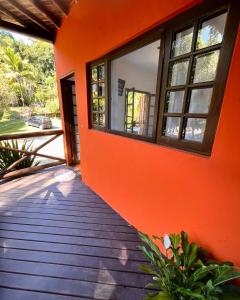 an orange building with a window and a wooden walkway at Pousada Chalés Sinbad in Ilhabela +45 photos
