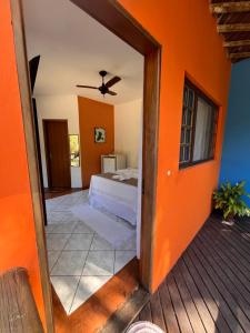 a bedroom with a bed and an orange wall at Pousada Chalés Sinbad in Ilhabela