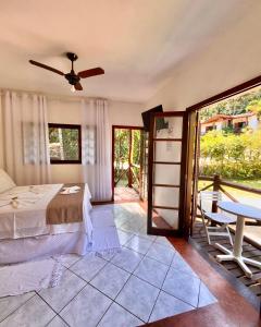 a bedroom with a bed and a table at Pousada Chalés Sinbad in Ilhabela