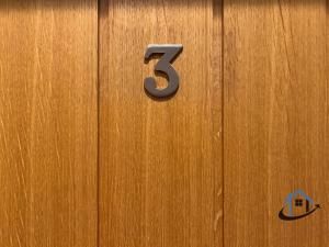 een houten deur met het nummer erop bij Coach House at The George Pub, Ashley, Market Harborough in Ashley