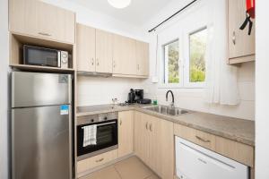 a kitchen with a stainless steel refrigerator and a sink at Villa Sequoia Yellow in Barbati