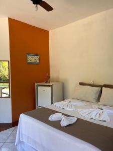 a bedroom with a bed with towels on it at Pousada Chalés Sinbad in Ilhabela