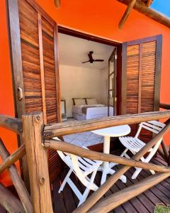 a balcony with two chairs and a bed in a room at Pousada Chalés Sinbad in Ilhabela
