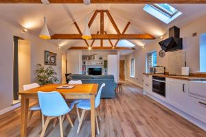 a kitchen and living room with a wooden table and chairs at Finest Retreats - The Asparagus Shed in Howell