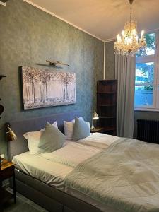 um quarto com uma cama e um lustre em BoLA Ferienwohnung Hamburg Nr 22 EG für 4 Personen, Parkplatz em Hamburgo