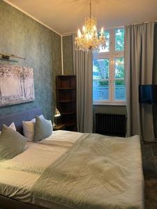 um quarto com uma cama com um lustre e uma janela em BoLA Ferienwohnung Hamburg Nr 22 EG für 4 Personen, Parkplatz em Hamburgo
