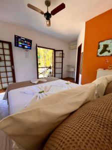 a bedroom with two beds and a ceiling fan at Pousada Chalés Sinbad in Ilhabela