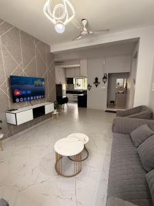 a living room with a couch and a table at Sukruthi service apartment 3BHK in Mangalore