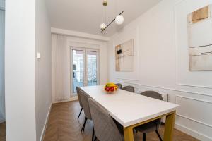 una sala da pranzo con tavolo e sedie bianchi di Villa Oasis Aria a Mostar