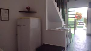 a white refrigerator in a kitchen with a staircase at Condomínio Vila Gustavo excelente localização in Caraguatatuba