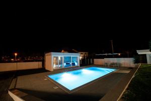 a large swimming pool in a backyard at night at Villa Oasis Aria in Mostar +88 photos