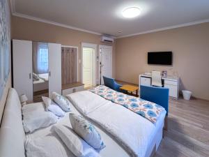 Un dormitorio con una cama, un sofá y un televisor. en Camille Apartmanhouse, en Budapest