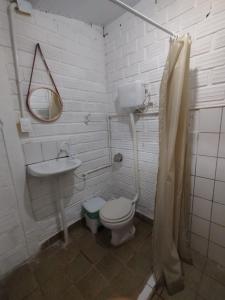 Un baño con inodoro, lavabo y espejo. en La foca da Croa, en Goiana 15 fotos más