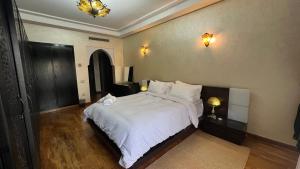 um quarto com uma cama grande com lençóis e travesseiros brancos em Dar Salma em Tânger