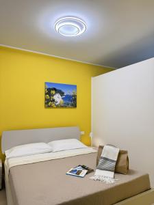 een slaapkamer met een bed en een gele muur bij Cantico del Mare in Recanati