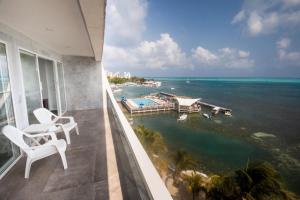 Un balcón con sillas y vistas al océano. en Apartamento Torres Sunrise Beach, en San Andrés