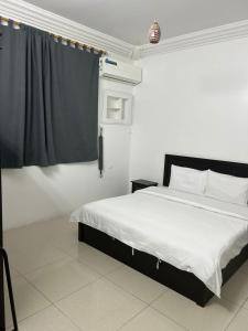 ein Schlafzimmer mit einem Bett und einem schwarzen Vorhang in der Unterkunft شقق ضيافة المصيف للشقق المخدومة in Ta'if