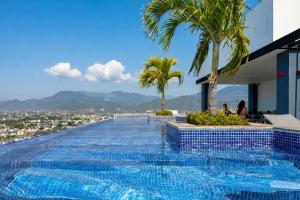 a swimming pool on the side of a building with palm trees at Paradise Escape Life is Good in Puerto Vallarta