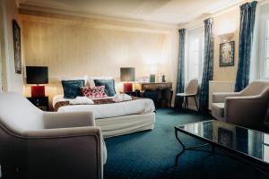 a hotel room with a bed and a table and chairs at Hôtel Le D'Avaugour in Dinan