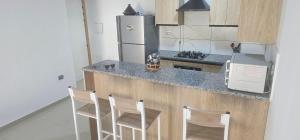 eine Küche mit einer Theke mit Stühlen und einem Kühlschrank in der Unterkunft Residence fedi in Monastir + 3 Fotos