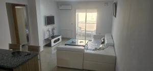 a white living room with a couch and a table at Residence fedi 12 in Monastir