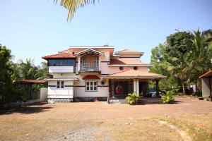 a large house with a large driveway at Raghavendra Homestay in Kalyānpur