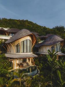 un gruppo di case con tetti di paglia di Mambo Villas a Kuta Lombok