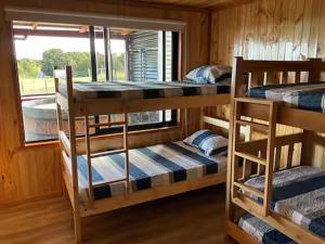 ein Zimmer mit drei Etagenbetten in einer Kabine in der Unterkunft Chiloé,Curaco de Velez casa de veraneo in Curaco de Velez + 35 Fotos