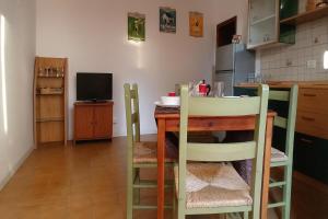 uma cozinha com uma mesa e cadeiras e uma televisão em Blu Mare em Punta Marina