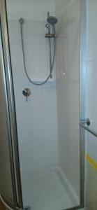 um chuveiro com porta de vidro em um banheiro em Blu Mare em Punta Marina