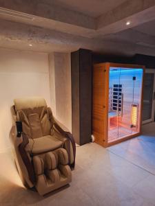 Un sillón reclinable marrón en una habitación con balcón. en CASA 9 - villa & spa, en Eşelniţa