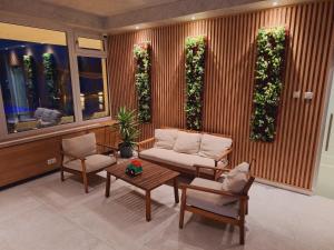 Una sala de estar con un sofá, una mesa y sillas. en CASA 9 - villa & spa, en Eşelniţa