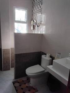 a bathroom with a toilet and a sink and a window at Huan Janto Homestay - Metta in Chiang Mai +9 photos