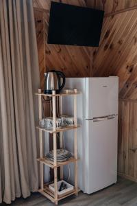 a kitchen with a white refrigerator and a wooden shelf at Sadyba u Halyny in Bukovel
