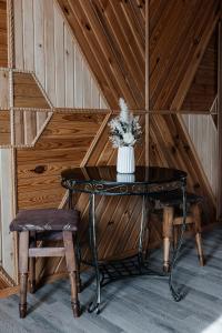 a table with a vase of flowers and two chairs at Sadyba u Halyny in Bukovel
