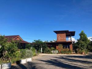 a house with a driveway with a building at Huan Janto Homestay - Metta in Chiang Mai