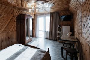 a bedroom with wooden walls and a bed in a room at Sadyba u Halyny in Bukovel