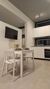 a white dining room table with chairs and a tv at Interno 8 in Padova