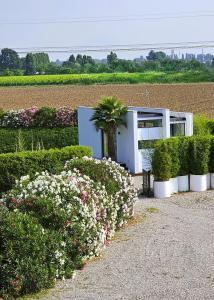 a white building with bushes and flowers in front of it at Interno 8 in Padova