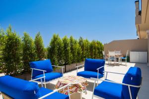 un groupe de chaises et de tables bleues sur une terrasse dans l'établissement Nostalgia, à Tortolì