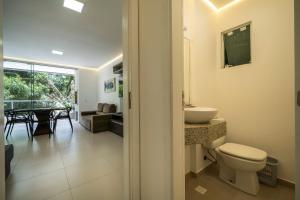 uma casa de banho com um WC, um lavatório e uma mesa em Seu Paraíso em Bombinhas Apto Totalmente Equipado a 3 Minutos da Areia em Bombinhas mais 55 fotografias