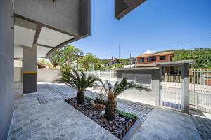 um pátio com palmeiras e pedras em uma casa em Seu Paraíso em Bombinhas Apto Totalmente Equipado a 3 Minutos da Areia em Bombinhas