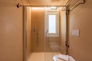 une salle de bain avec douche, toilettes et fenêtre dans l'établissement Nostalgia, à Tortolì 32 autres photos