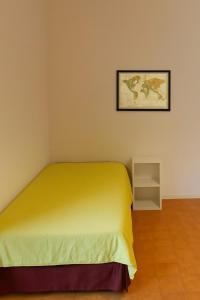 um quarto com uma cama amarela e uma imagem na parede em Blu Mare em Punta Marina