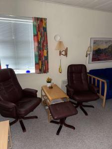 een woonkamer met 2 stoelen en een tafel en een bed bij Summerhouse in Liseleje in Liseleje