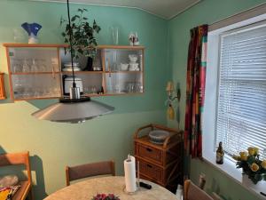 een keuken met een tafel en een kroonluchter bij Summerhouse in Liseleje in Liseleje +10 foto's