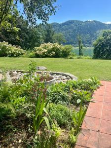 SattendorfにあるSeeblick mit Charme in der Villa Hirschfischの湖の横に石の歩道がある庭園 +5枚の写真